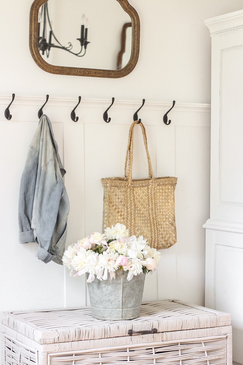 Bucket of peonies styled in an entryway