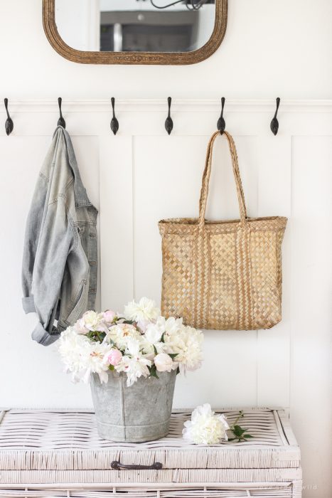 Bucket of peonies styled in an entryway