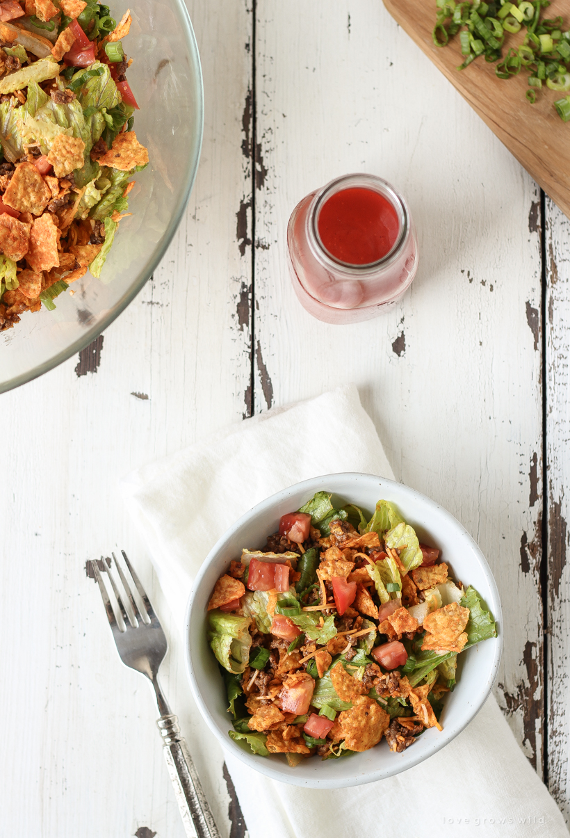 A delicious taco salad made with fresh produce, flavorful seasoned beef, crunchy Dorito chips and a special tangy dressing! This party favorite is fast, fresh, delicious, and always a crowd-pleaser!