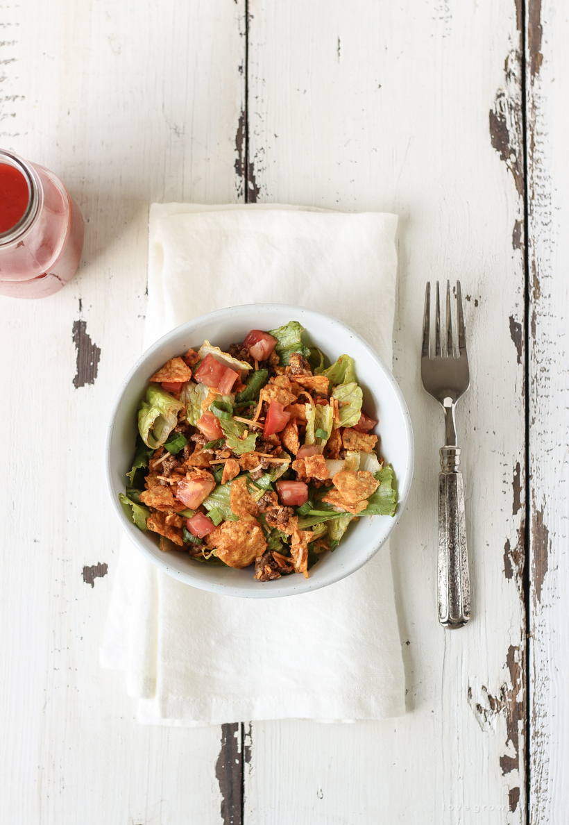 A delicious taco salad made with fresh produce, flavorful seasoned beef, crunchy Dorito chips and a special tangy dressing! This party favorite is fast, fresh, delicious, and always a crowd-pleaser!