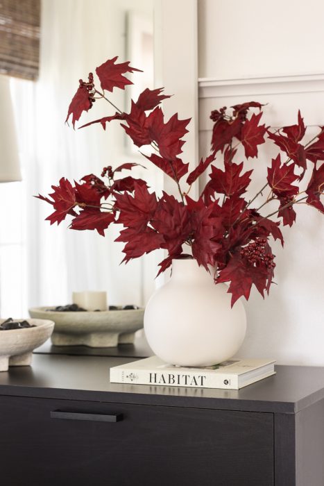 Home blogger and interior decorator Liz Fourez shares a beautiful fall vignette in her dining room featuring deep red fall branches and a new furniture find that has a high-end look without the high-end price