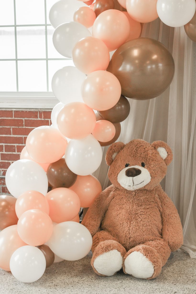 Decorating ideas for the sweetest teddy bear themed baby shower with an easy photo backdrop, diy balloon garland, and teddy bear balloon centerpieces. See all the details on lovegrowswild.com
